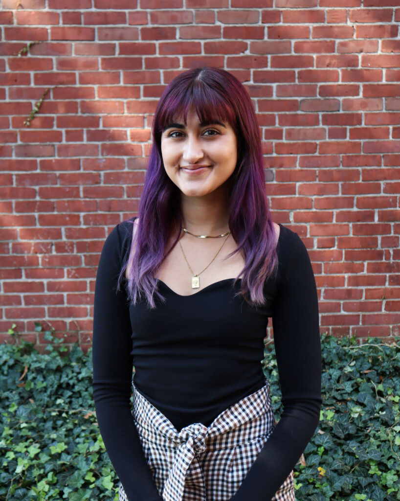 Aashna Avachat black long-sleeved shirt standing against brick wall