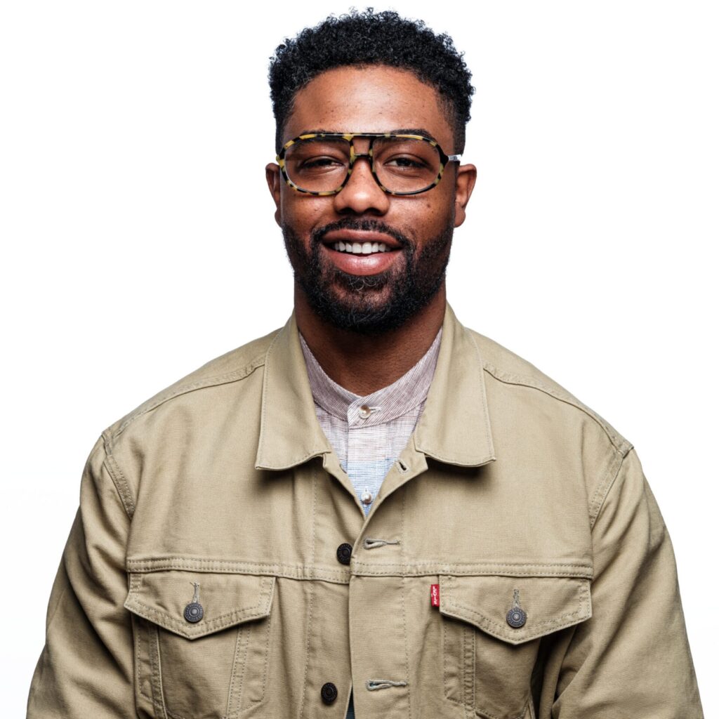 Tyler Whittenberg headshot beige button-down shirt, white background.