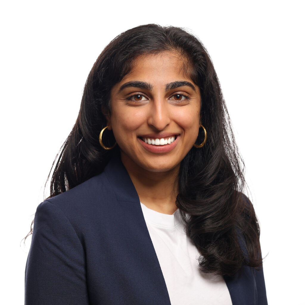Megan Patel Headshot, navy blazer, white blouse, in front of a white background.