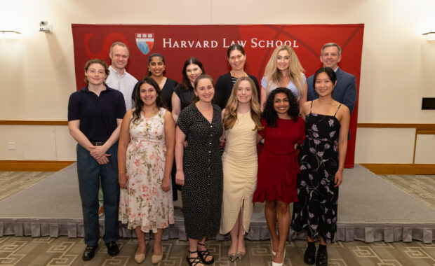 Graduating Y-Lab Fellows and Faculty Leaders in front of HLS banner.