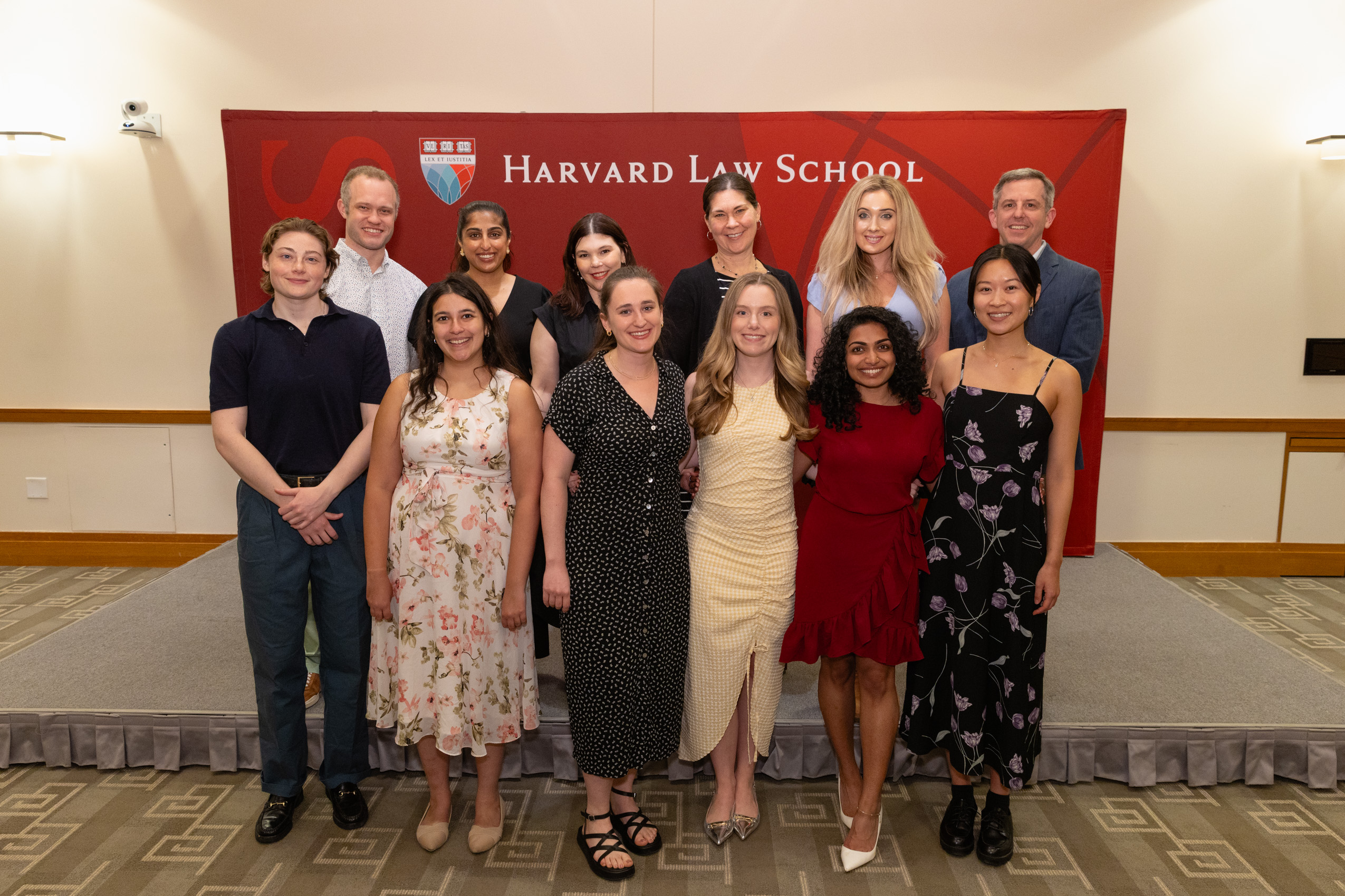 Graduating Y-Lab Fellows and Faculty Leaders in front of HLS banner.