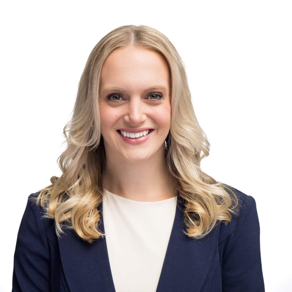 Headshot Lindsay Fincher, navy blue blazer, white shirt, and white background.