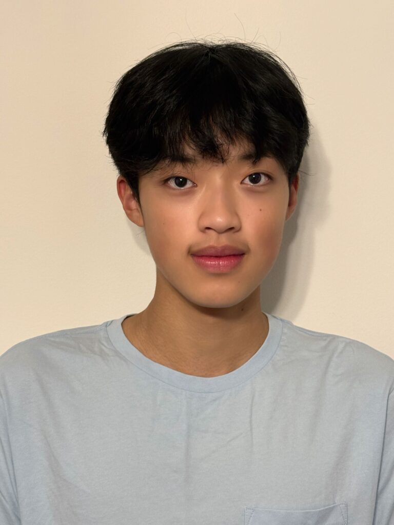 Kevin Tse headshot, standing in front of white wall, wearing gray shirt.
