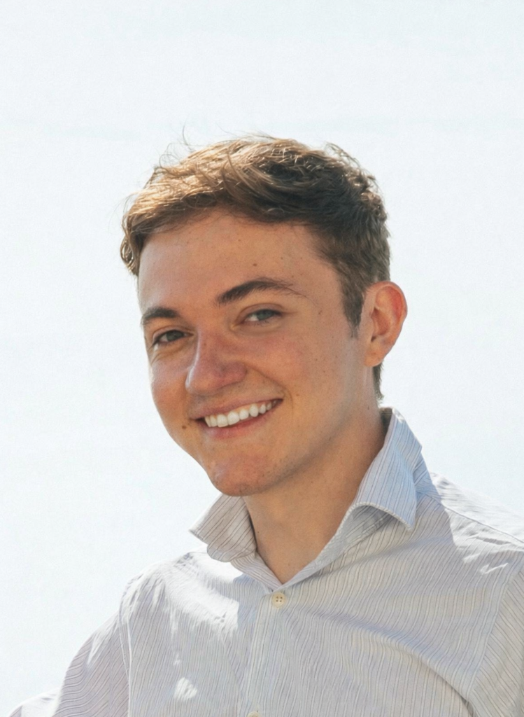 Hudson Patterson headshot, wearing white shirt, standing in front of white background.