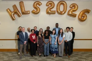 Y-Lab Fellows group photo in front of white wall with gold HLS 2026 balloons.