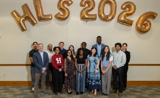 Y-Lab Fellows group photo in front of white wall with gold HLS 2026 balloons.